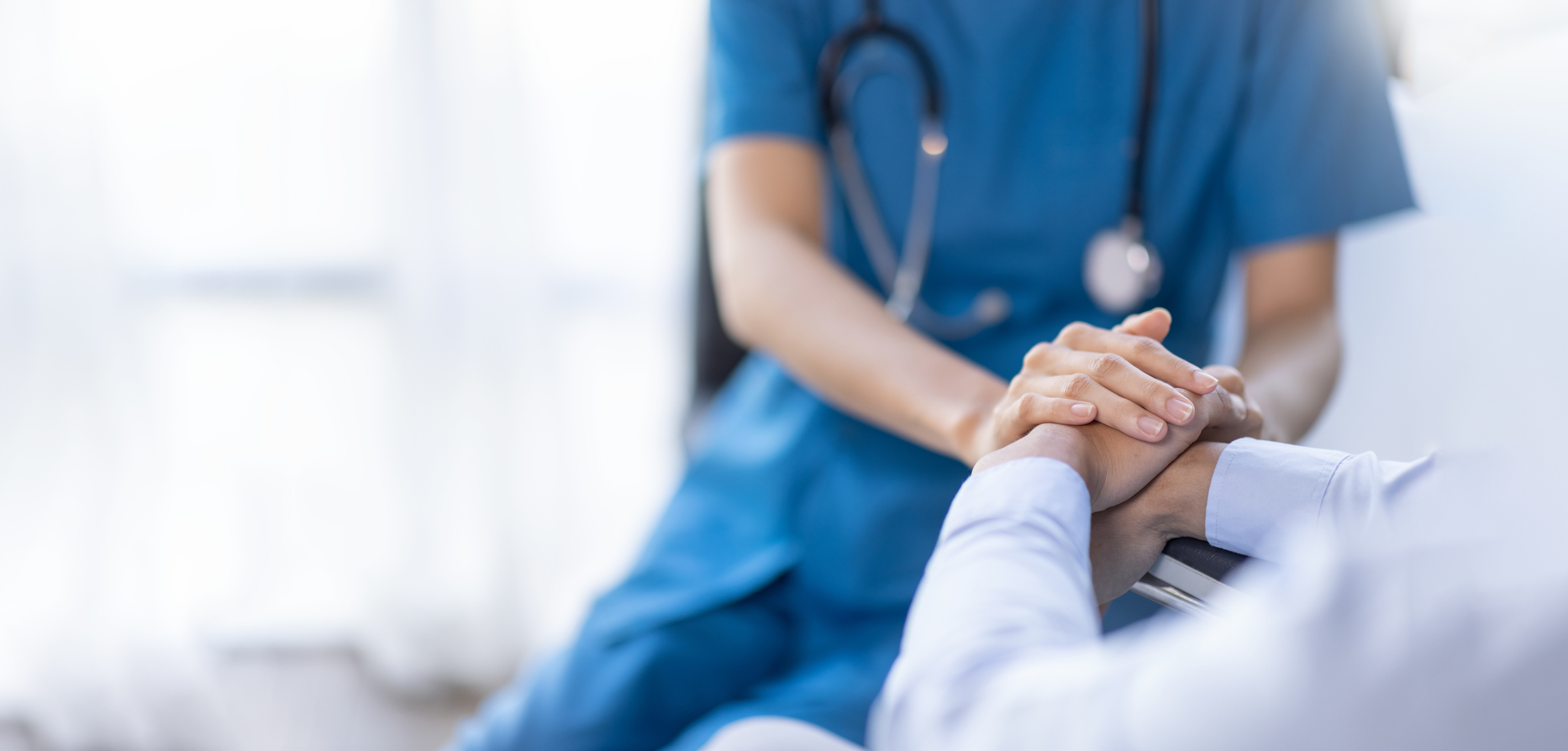 Anästhesie - Ein Arzt hält die Hand eines Patienten zur Beruhigung
